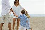 Family playing ring-around-the-rosy at the beach