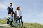 Parents and young boys standing on meadow, portrait