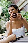 Young woman with cup of coffee outdoors