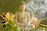 Statuette de Bouddha avec fleurs et fumée