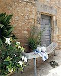 Wooden bench with carafe of milk in front of stone house