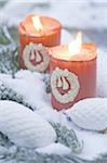 Two burning candles in snow