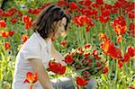 Woman surrounded by red tulips