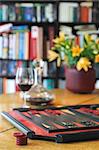 Backgammon set and glass of red wine