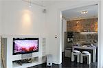 Modern open plan kitchen and widescreen TV in living room