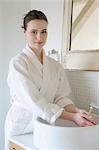 Young woman washing hands in bathroom