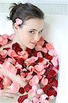 Young woman enjoying bath with rose petals