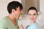 Young woman feeding man with salad