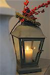 Lantern with burning candle and twig