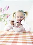 Girl eating strawberries with milk