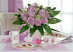 Bunch of roses and coffee set on dining table
