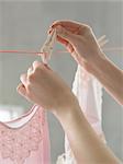 Woman hanging pink nightdress on clothesline