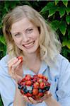 Happy woman holding bowl with fruit