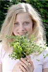 Smiling woman holding herbs