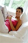 Young woman reading magazine on couch