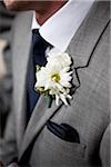 Gros plan de la boutonnière sur la boutonnière du marié