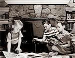 1950ER JAHRE KINDER SPIELEN SCHALLPLATTEN UND BÜCHER LESEN, KAMIN