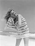 ANNÉES 1950 - ANNÉES 1960 BLONDE FEMME ENVELOPPÉE DANS DÉNUDÉE SERVIETTE DE SÉCHAGE DES CHEVEUX SUR LA PLAGE SOURIANT