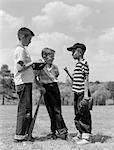 1950s BOYS BASEBALL THREESOME ONE HOLDING BAT OTHERS WEARING MITTS HAVING DISCUSSION