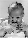 1960s PORTRAIT OF SMILING BABY INDOOR MAKING A FUNNY FACE