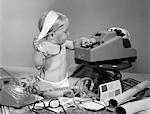 1960s BABY WITH ADDING MACHINE TELEPHONE BLUEPRINTS PAINT SAMPLES AND TAPE MEASURE