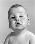 1960ER JAHRE PORTRAIT BABY MIT GROßEN JOWLS & BLÖD AUF GESICHT, BLICK IN DIE KAMERA SCHAUEN