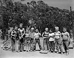 1950s LINE-UP OF 9 BOYS IN TEE SHIRTS WITH BATS & MITTS FACING CAMERA