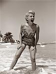 1950s LAUGHING BLONDE WOMAN IN STRAPLESS LOW CUT BATHING SUIT SWIM WEAR WADING UP TO ANKLES IN SURF