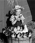 1950s FARM BOY HOLDING DUCKLING SITTING BY BASKED FILLED WITH MOTHER DUCK AND BABIES