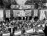 1950s CROWD GATHERED IN FRONT OF STAGE AT COUNTY FAIR FREAK SHOW