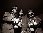 1950s TRIO OF RESCUE SQUAD FIREMEN WEARING RESPIRATOR MASKS CARRYING FLASHLIGHTS AND FIRE EQUIPMENT