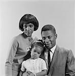 1960s AFRICAN-AMERICAN FAMILY PORTRAIT FATHER MOTHER DAUGHTER LOOKING AT CAMERA