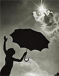 SILHOUETTE D'ENFANT DES ANNÉES 1960 PERMANENT AVEC PARAPLUIE SOUS BRIGHT SUN