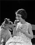 1920s - 1930s WIRE HAIR TERRIER DOG WATCHING YOUNG GIRL EATING COOKIE