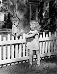 1940s BOY GIRL HOLDING BALL TALKING FLIRTING OVER WHITE PICKET FENCE NEIGHBORS