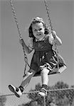 1940s SMILING GIRL SWINGING ON PLAYGROUND SWING