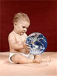 1960s SYMBOLIC ECOLOGY SERIOUS BABY WEARING CLOTH DIAPERS SITTING HOLDING LOOKING AT THE EARTH