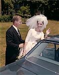 1960s COUPLE BRIDE & GROOM GETTING INTO CAR AFTER WEDDING