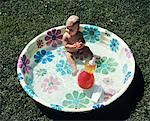 1970s BABY SITTING IN PLASTIC BACKYARD KIDDY POOL VIEWED FROM ABOVE