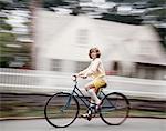 1970s BLURRED MOTION YOUNG GIRL IN YELLOW SHORTS WHITE KNEE SOCKS RIDING BLUE BIKE