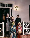 1960ER JAHRE GRUPPE KINDER IN HALLOWEEN-KOSTÜMEN AUF DER VERANDA SÜßES ODER SAURES