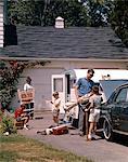 1960s FAMILY FATHER MOTHER 3 SONS LOADING CAR AND TRAILER FOR CAMPING VACATION