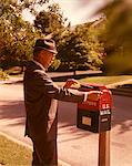 1960s MAN BUSINESS MAN SUIT HAT MAILING LETTER MAILBOX MAIL DROP BOX POST POSTAL SUBURBAN STREET