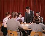 GROUPE DES ANNÉES 1960 DE SIX ÉTUDIANTS AT ASSIS AUTOUR D'UNE TABLE TALKING TROIS GARÇONS TROIS FILLES ADOLESCENTES INTÉRIEURE