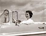 1950s SMILING WOMAN DRIVING CHEVROLET CONVERTIBLE AUTOMOBILE