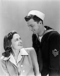 ANNÉES 1940 SOURIANT COUPLE HOMME FEMME MARINE UNIFORME