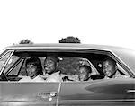 1960s SIDE VIEW OUTDOOR SMILING AFRICAN-AMERICAN FAMILY FATHER MOTHER TWO SONS SITTING IN FOUR DOOR SEDAN AUTOMOBILE