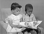 ANNÉES 1960 GARÇON AFRO-AMÉRICAIN ET LE LIVRE DE LECTURE DE FILLE ASSISE CHAISE