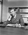 1960s BUSINESSMAN EXECUTIVE AT DESK TALKING ON TELEPHONE