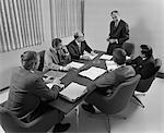 1960s 6 EXECUTIVE BUSINESSMEN AROUND CONFERENCE TABLE BOARD MEETING